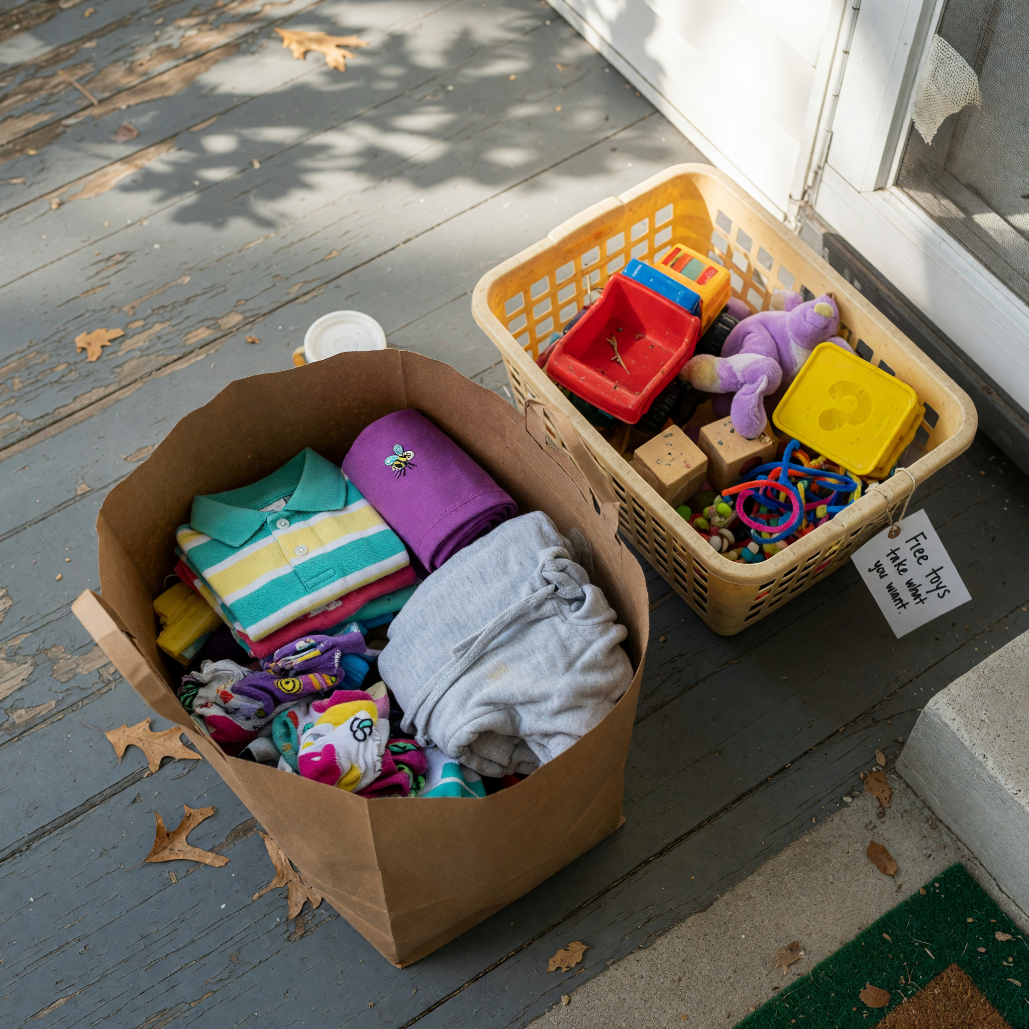 Folded kids’ clothing and a toy basket prepared for pickup.