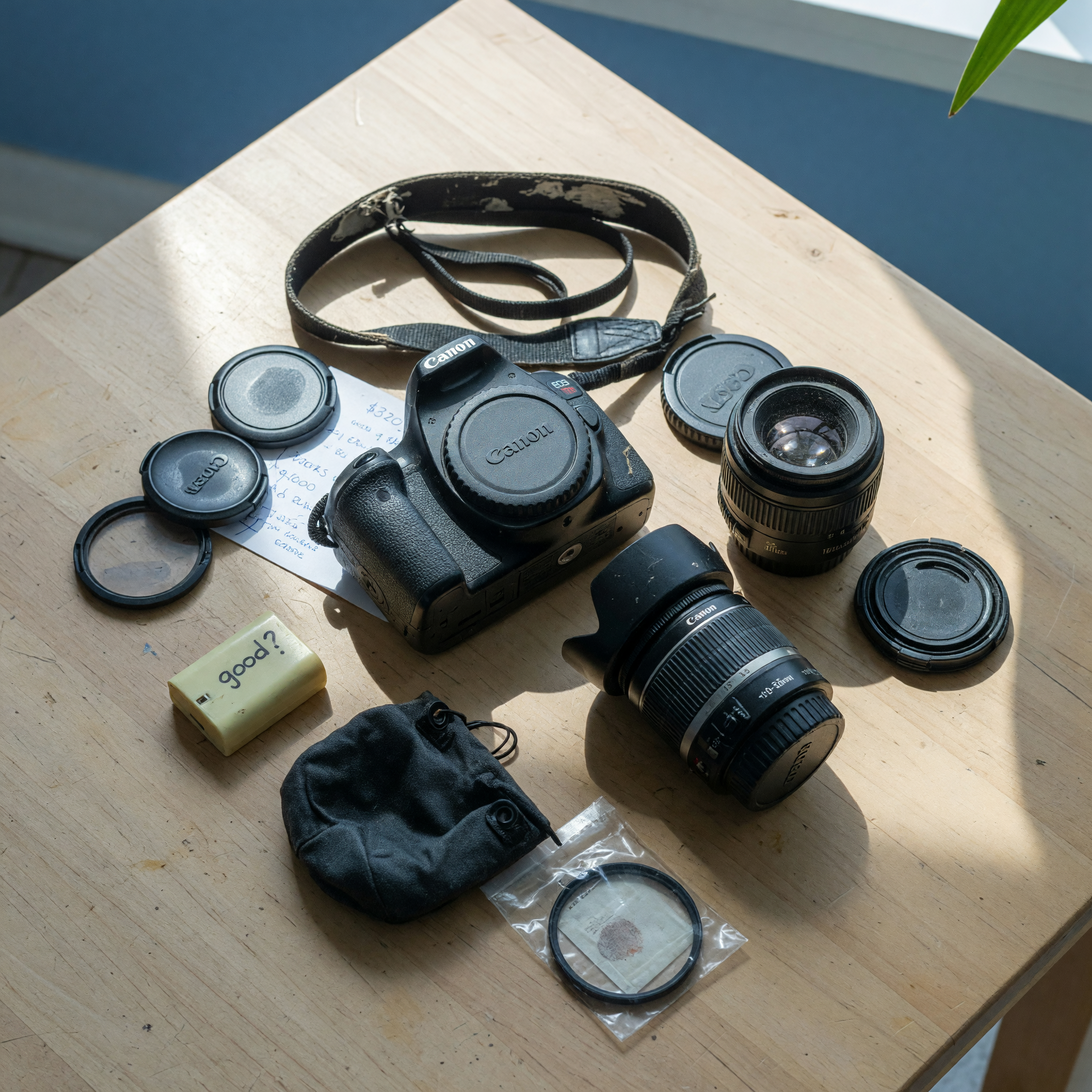 Flat lay of used camera gear with body, lenses, and accessories