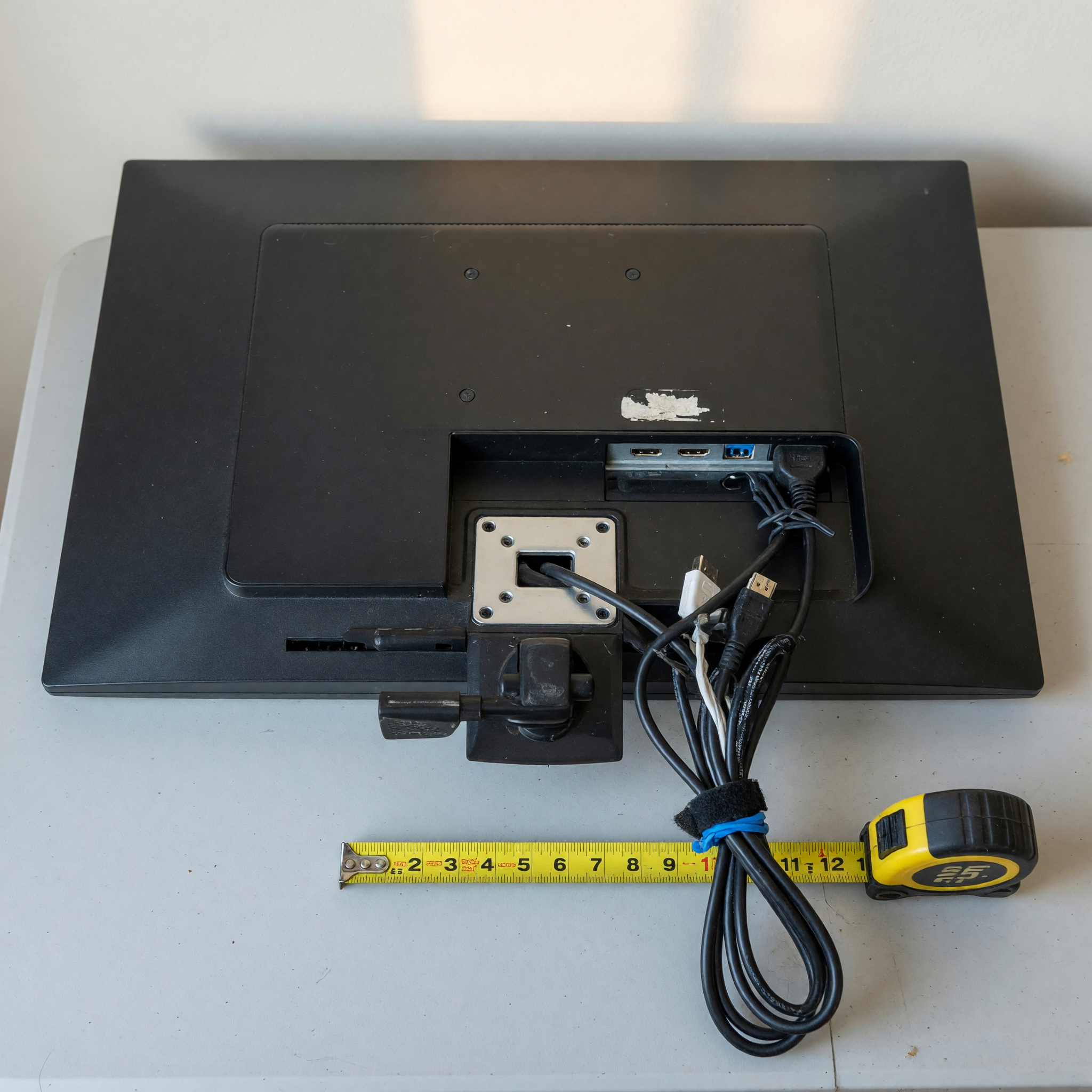 Back of a used computer monitor showing ports, cables, and measuring tape for a marketplace listing