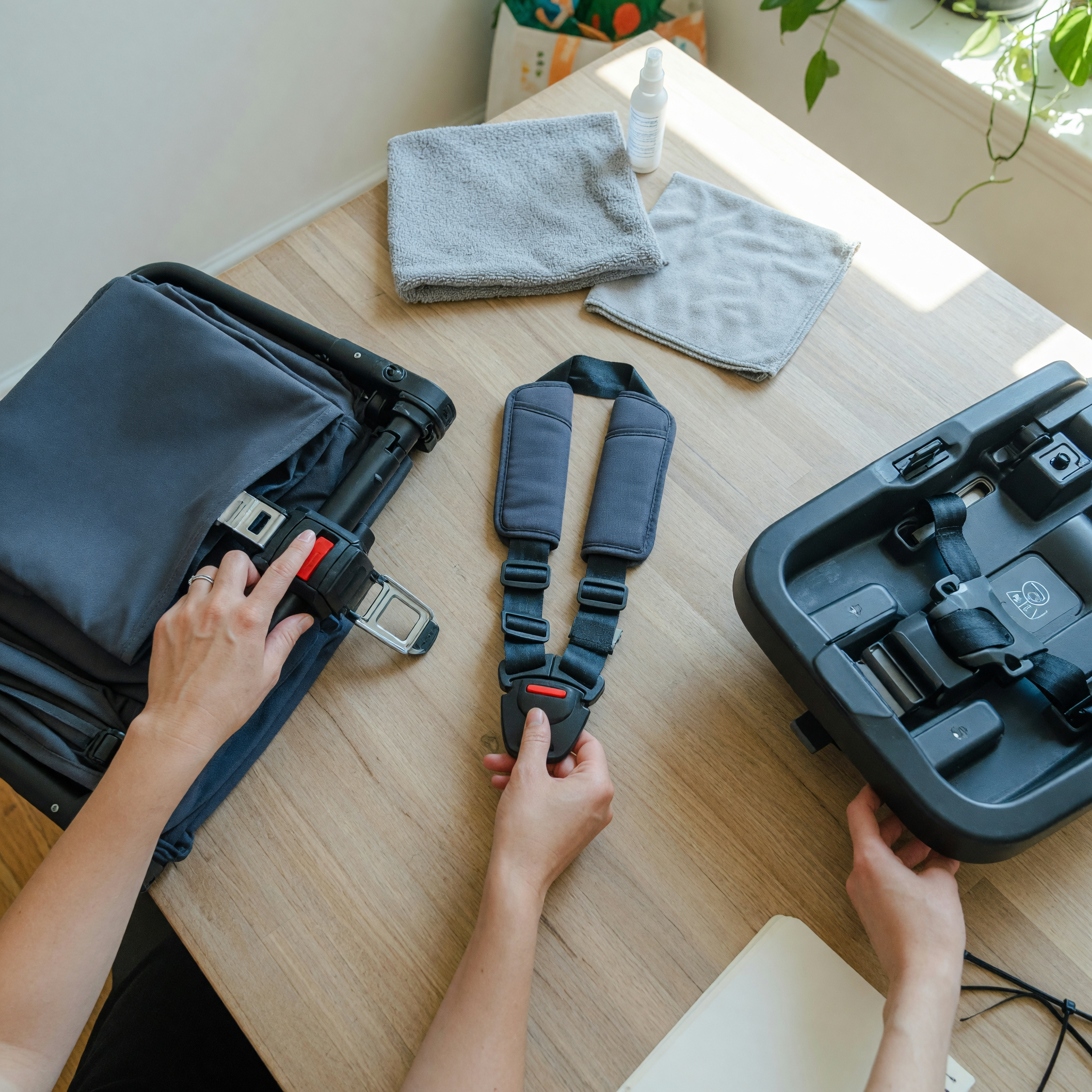 Seller checking a clean stroller latch, car seat harness, and base parts before writing a baby gear listing